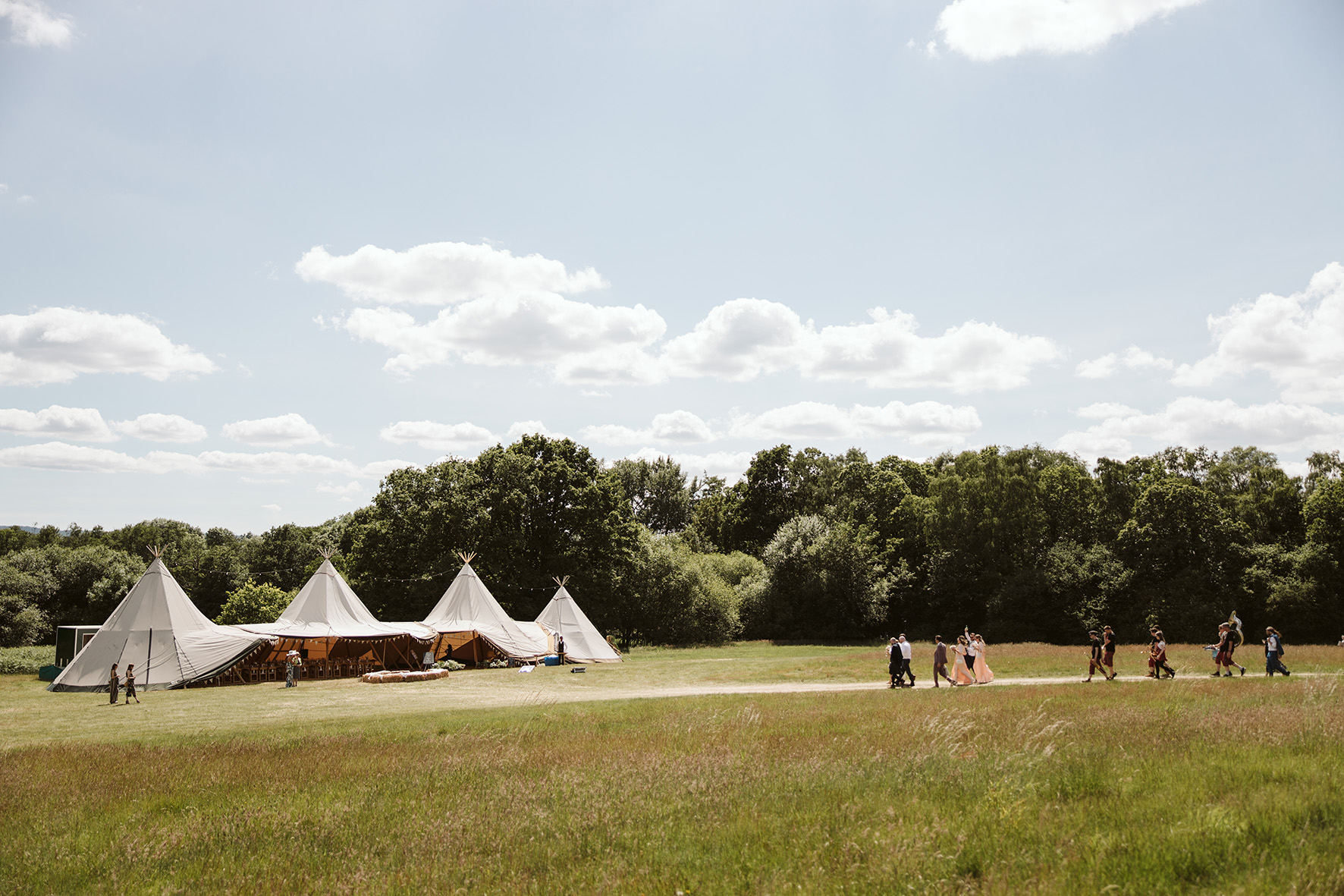 off-white tipis in a field