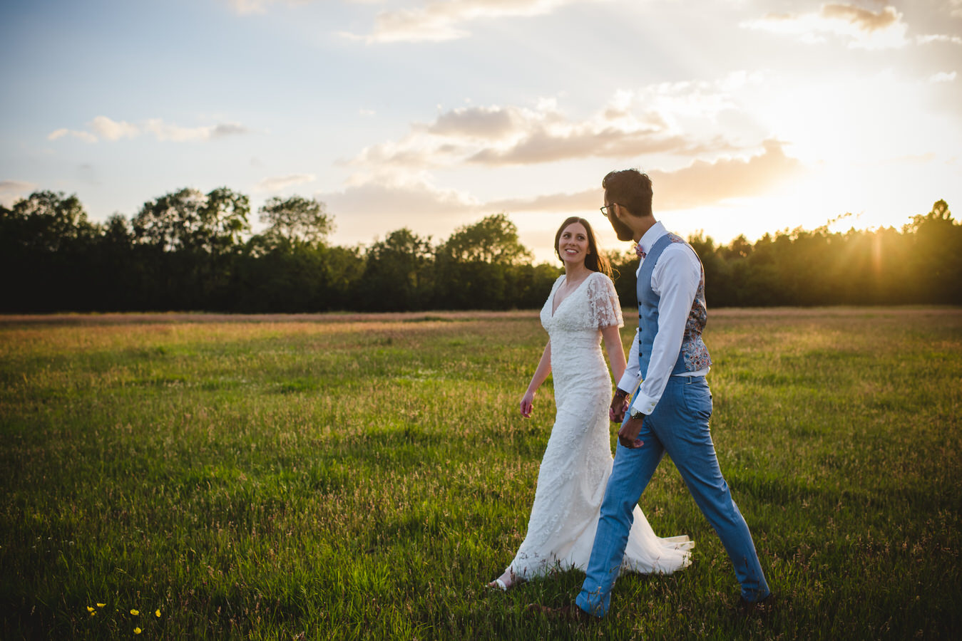 newly wed couple in a field at twilight