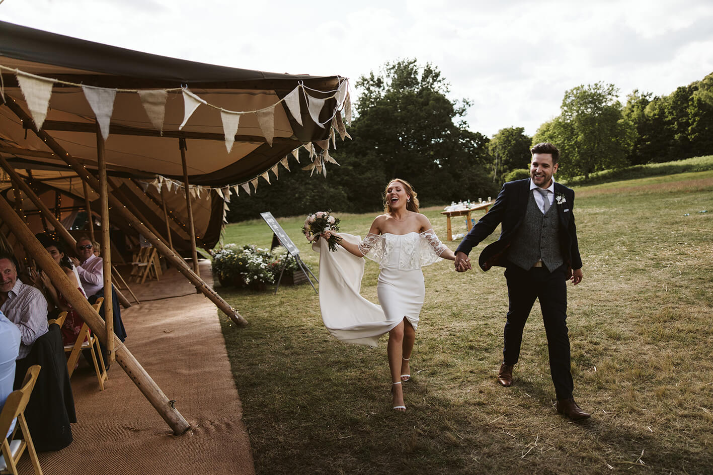 Wedded couple walking through their wedding tipi 