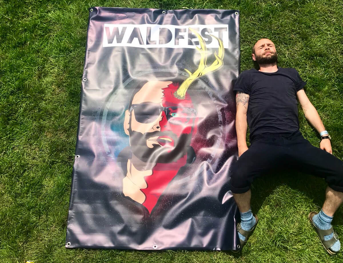 Man lying on grass next to a sign